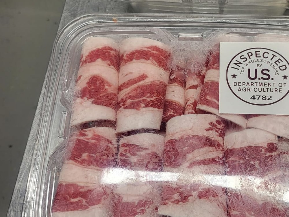 Thin-sliced beef rolls in a clear retail pack with USDA mark